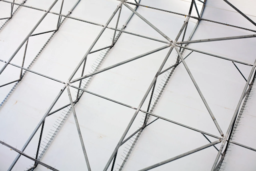 Close-up view of a steel frame supporting a fabric shelter, highlighting the robust structure and durability of steel-framed fabric shelters.